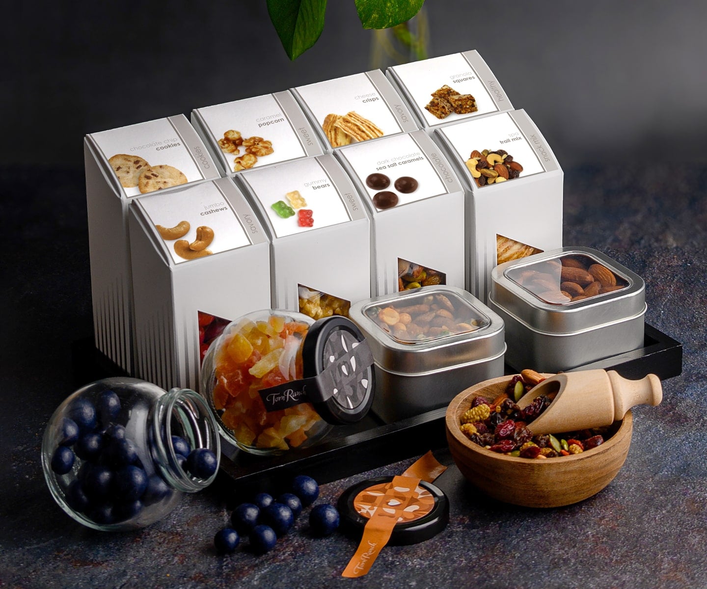 Modern hotel minibar stocked with Torn Ranch gourmet truffles, nuts, and popcorn presented as luxury in-room amenities.