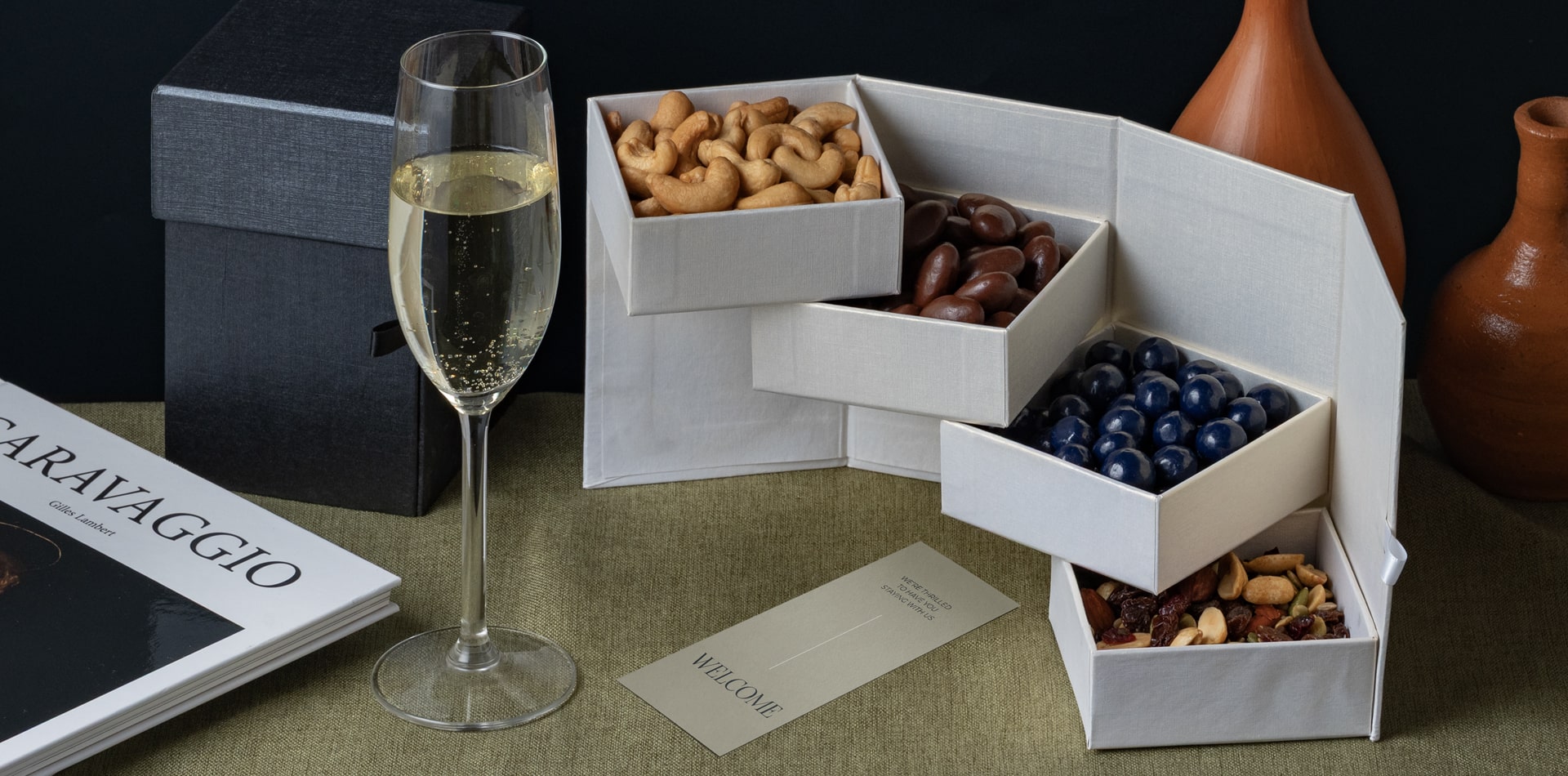 A beautifully lit boutique hotel room with a welcome amenities and glass of champagne